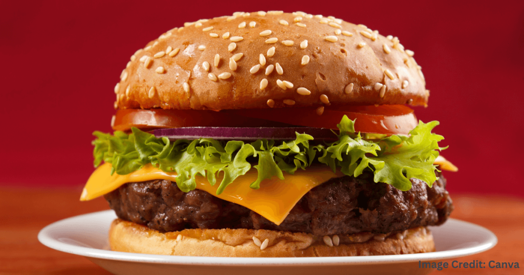 참깨 번에 치즈, 상추, 토마토, 양파가 올라간 육즙 가득한 치즈버거 (Juicy Cheeseburger with Sesame Bun, Cheese, Lettuce, Tomato, and Onion)
